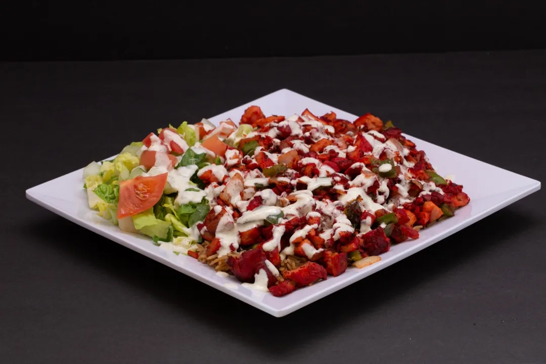 Chicken platter over basmati rice with salad and white sauce