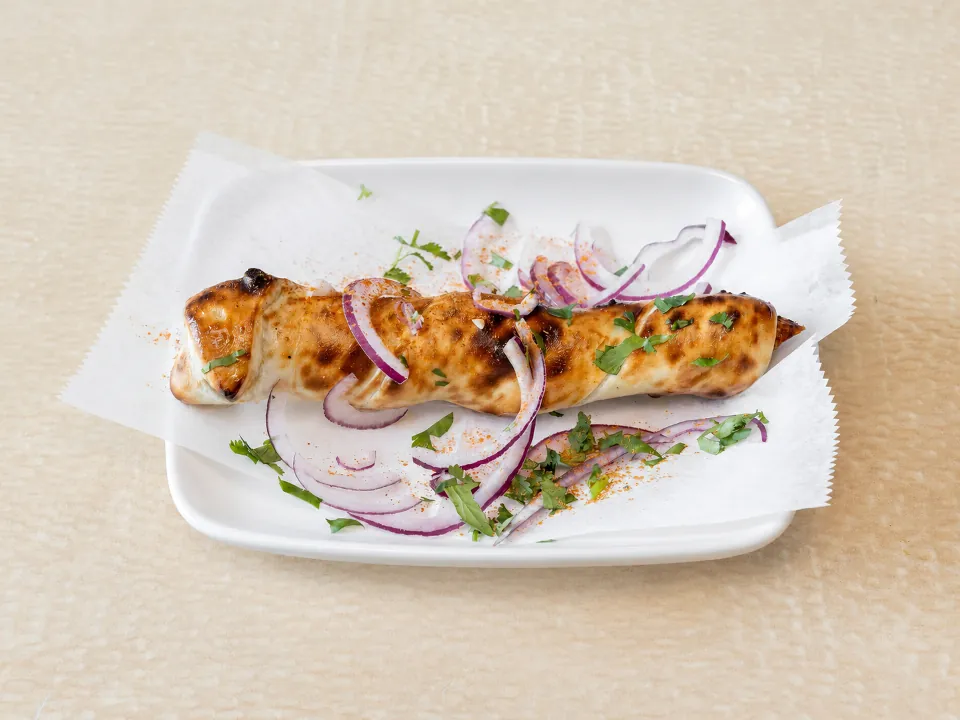 The Krazy Kabab Roll: a chicken seekh kabab baked inside naan, topped with red onion, chaat masala and cilantro